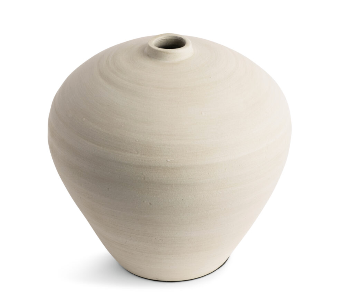 This smooth ceramic vase is combining functionality and sculptural elegance with its hand-formed round silhouette and cream finish