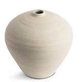 This smooth ceramic vase is combining functionality and sculptural elegance with its hand-formed round silhouette and cream finish