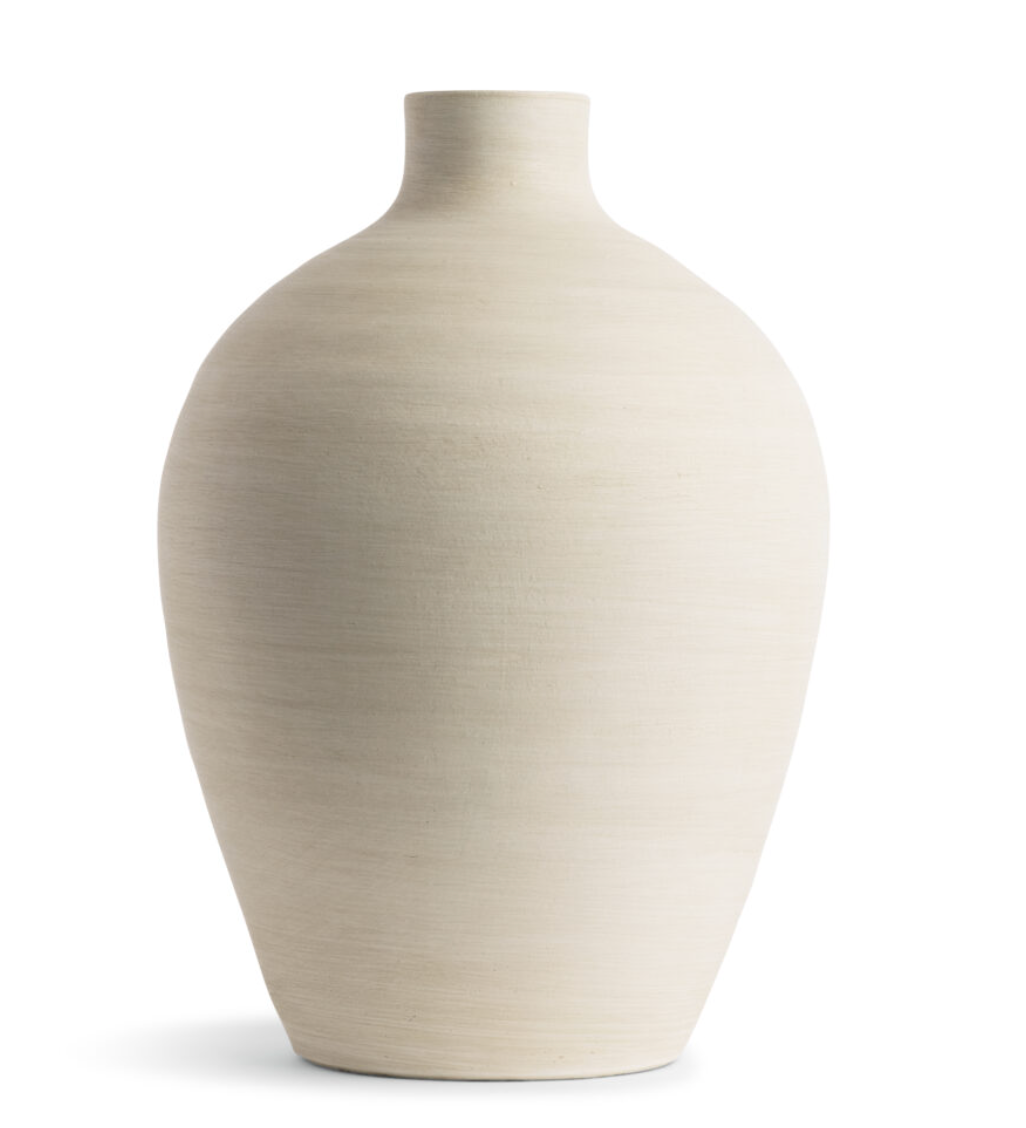 This smooth ceramic vase is combining functionality and sculptural elegance with its hand-formed round silhouette and cream finish