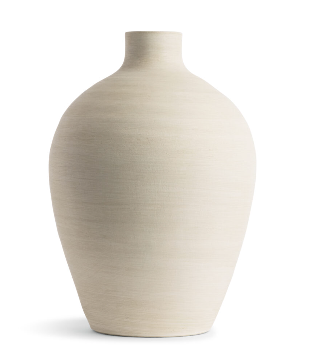 This smooth ceramic vase is combining functionality and sculptural elegance with its hand-formed round silhouette and cream finish