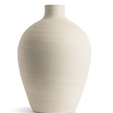 This smooth ceramic vase is combining functionality and sculptural elegance with its hand-formed round silhouette and cream finish