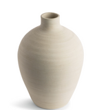 This smooth ceramic vase is combining functionality and sculptural elegance with its hand-formed round silhouette and cream finish