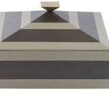 Tonal stripes add a tailored finish to a two-toned dove and graphite leather box. This pyramid-inspired accessory is topped with a bronze-plated handle that reflects its geometric lines. Lined in soft suede. 