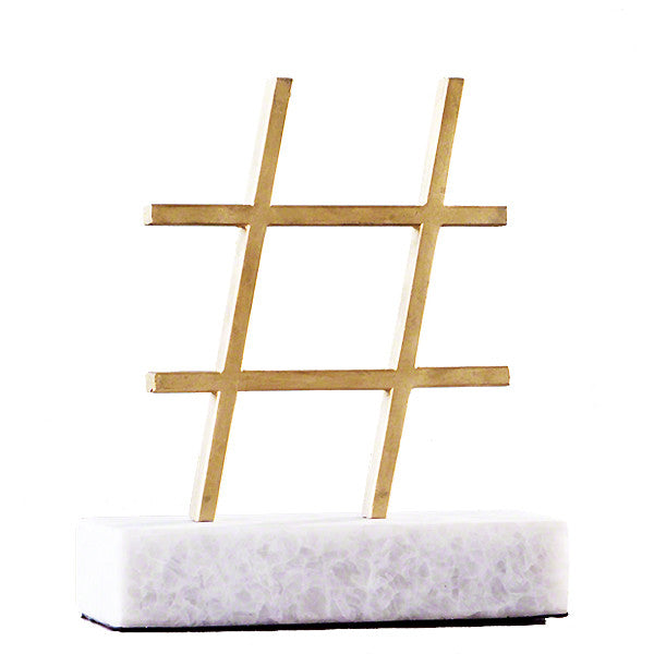 Gold leaf cast iron hashtag on a marble stand is at once elegant and humorous. 
